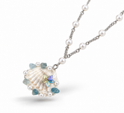 Angled front view of the seashell pendant with pearls and aqua beads.