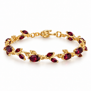 Gold-tone leaf vine bracelet with red teardrop stones.