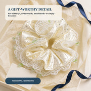 Ivory polka-dot satin and lace oversized scrunchie arranged in a gift box