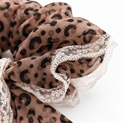 Close-up of gathered leopard chiffon and floral lace edging