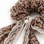 Close-up of leopard chiffon, ivory floral lace and pearl-look accent