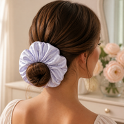 Woman wearing a pale lilac floral satin oversized scrunchie in a polished low bun
