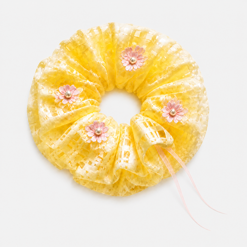 Butter yellow floral organza scrunchie on a neutral gray-white studio background